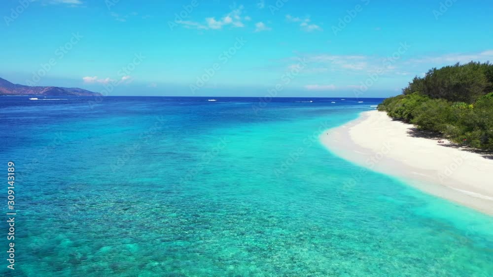 A Stunning Scenery Of Blue Calm Ocean With Glorious Trees and Cloudy Blue Sky Above in Bali, Indonesia A Stunning Scenery Of Blue Calm Ocean With Glorious Trees and Cloudy Blue Sky Above in Bali, Indonesia