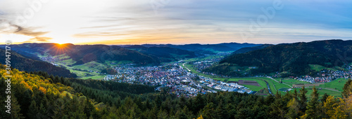 Germany, XXL aerial panorama view above black forest village haslach im kinzigtal and endless nature landscape over tree tops at sunset in autumn season