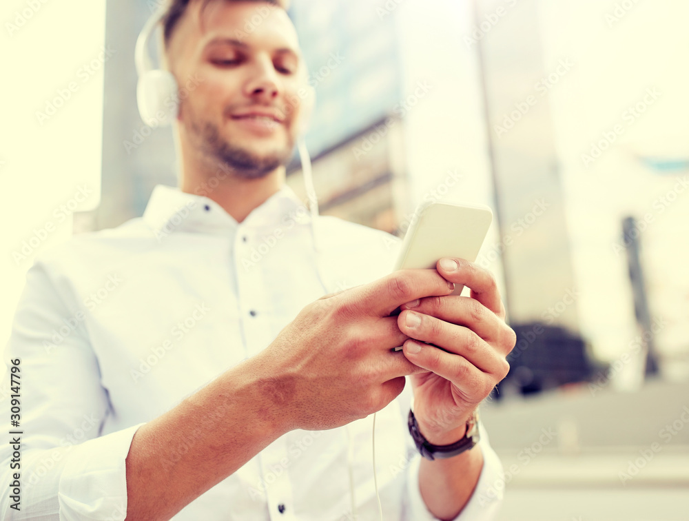 people, technology and lifestyle - man with smartphone and headphones listening music