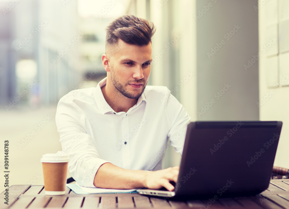 business, technology and people concept - young man with laptop computer and coffee cup at city street cafe business, technology and people concept - young man with laptop computer and coffee cup at city street cafe