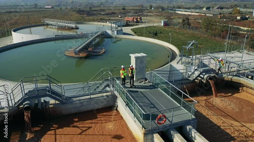 Engineers assessing waste water treatment plant with industrial drone