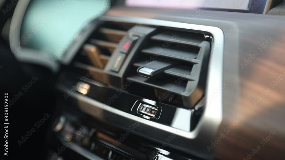 Close-up and soft focus. Button for emergency stop of the car and air duct deflector climate control in a premium car. Wood trim. Close-up and soft focus. Button for emergency stop of the car and air duct deflector climate control in a premium car. Wood trim.
