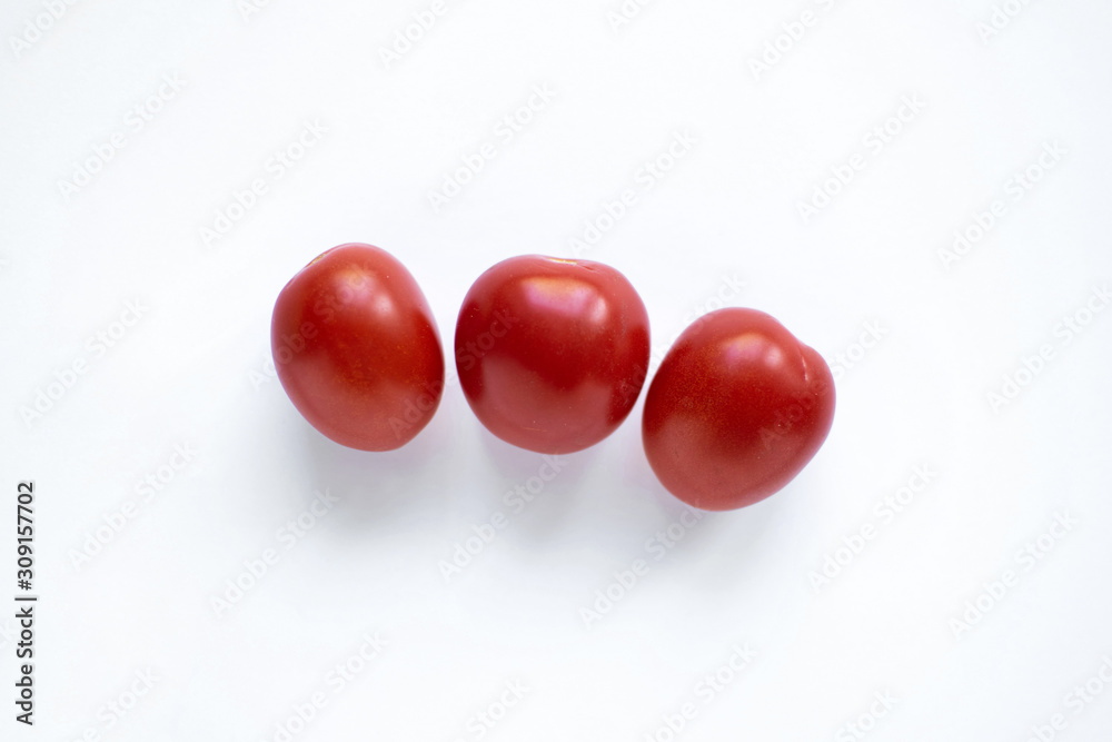 three small tomatoes isolated on white background three small tomatoes isolated on white background