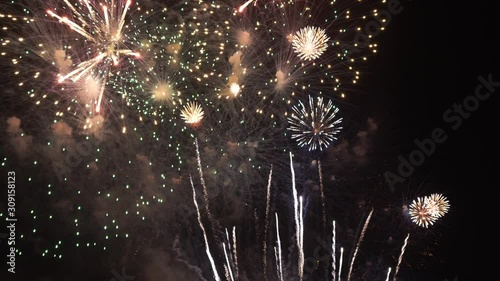 Multiple colorful fireworks explode filling the screen with the grand finale of a fireworks display. , photo