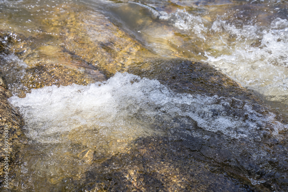 Calm water stream around the rocks