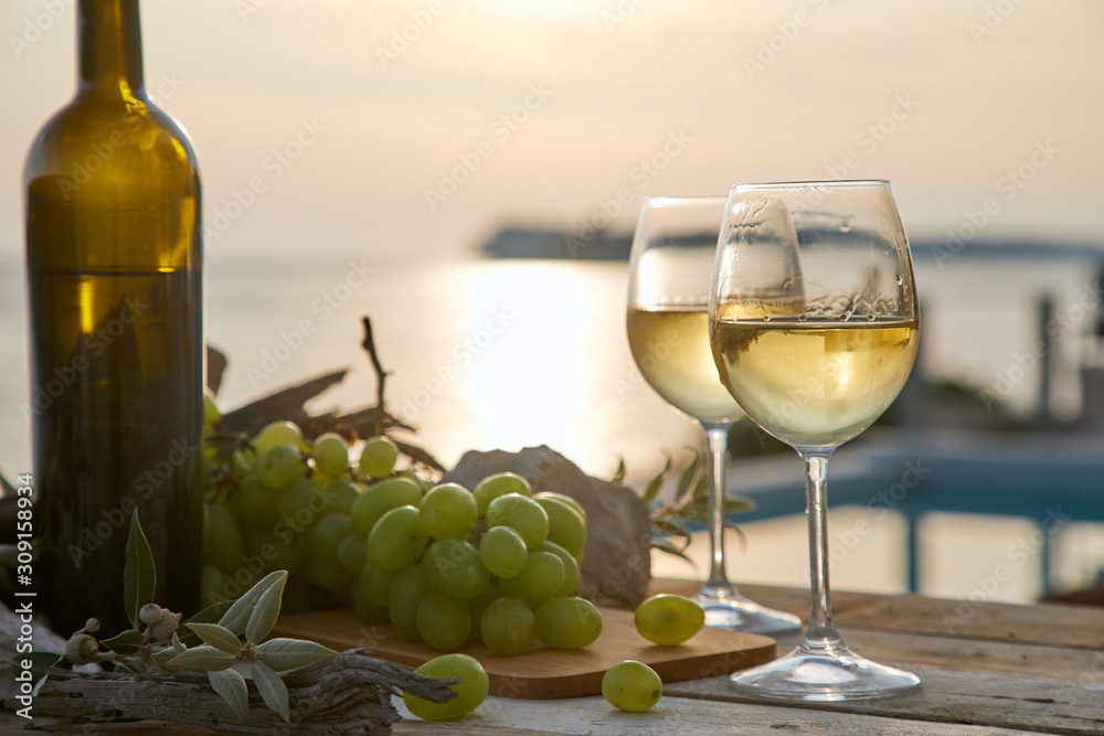 two glasses with wine during sunset time