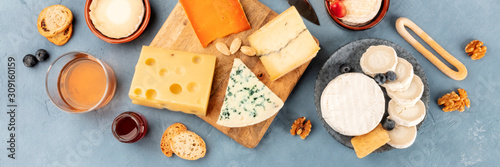 Cheese platter overhead panoramic shot. An assortment of different cheeses, shot from above on a slate background