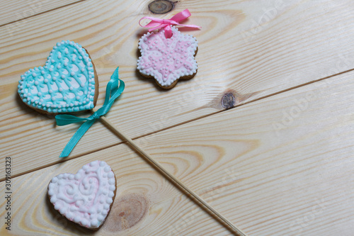 Spicy gingerbread cookie. On a stick and without it. Garnished with multicolored sugar glaze. Lies on pine boards.