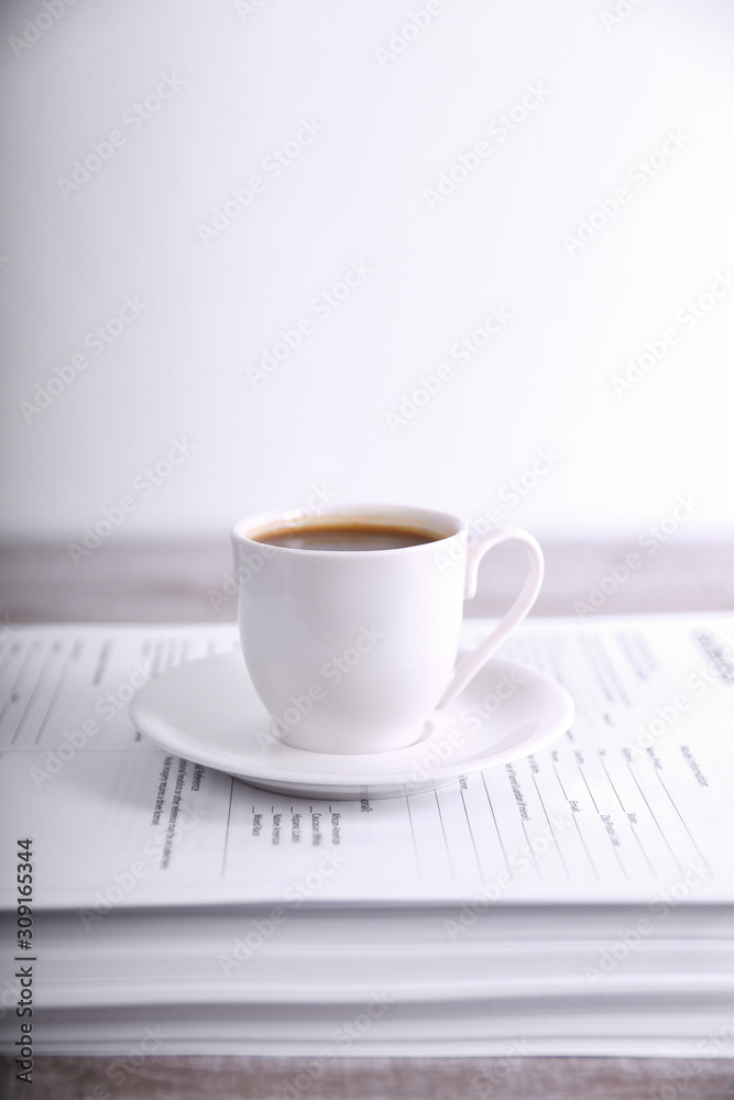 Take a break drink coffee concept. Cup of coffee on a stack of paper on the table Take a break drink coffee concept. Cup of coffee on a stack of paper on the table