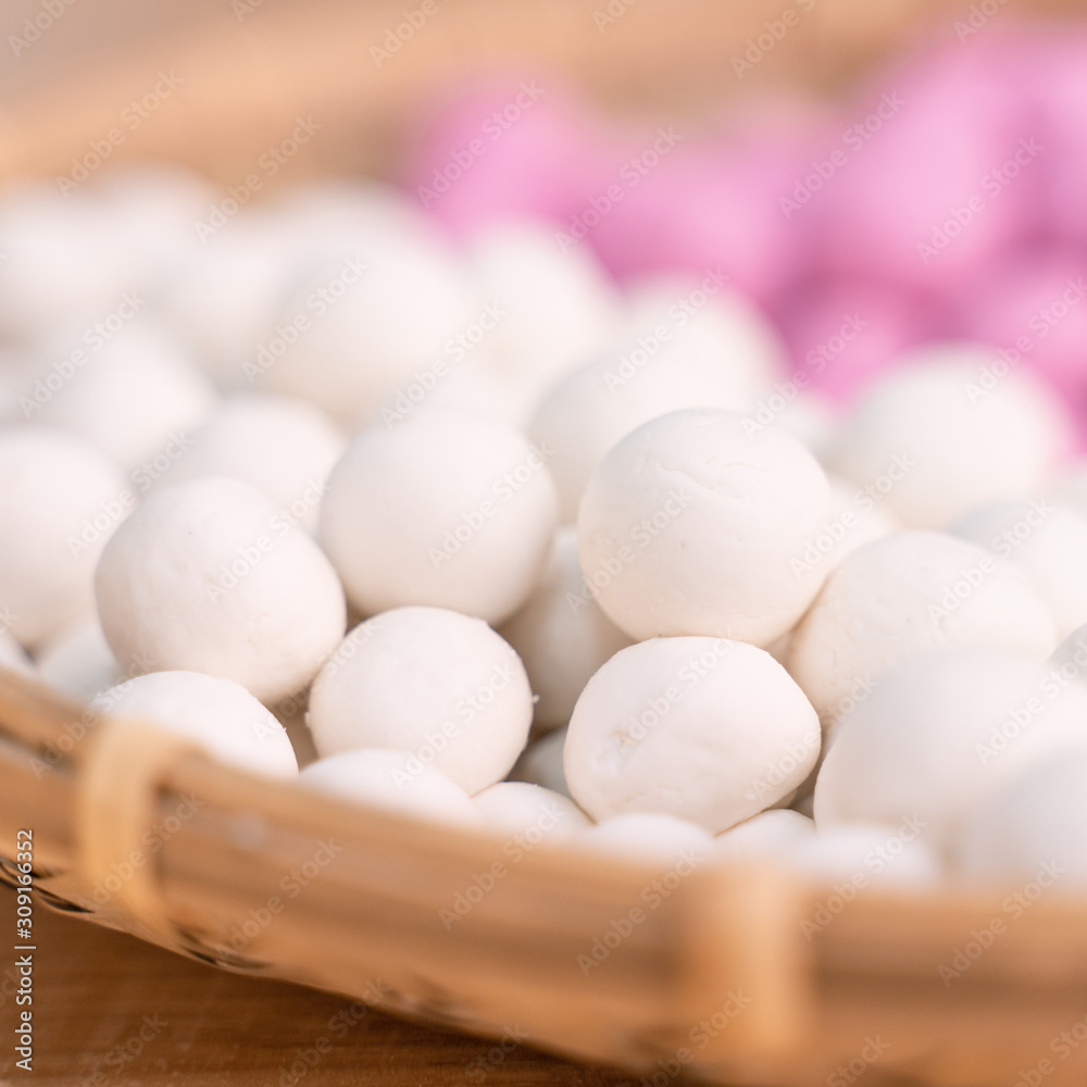 An Asia woman is making Tang yuan, yuan xiao, Chinese traditional food rice dumplings in red and white for lunar new year, winter festival, close up. An Asia woman is making Tang yuan, yuan xiao, Chinese traditional food rice dumplings in red and white for lunar new year, winter festival, close up.
