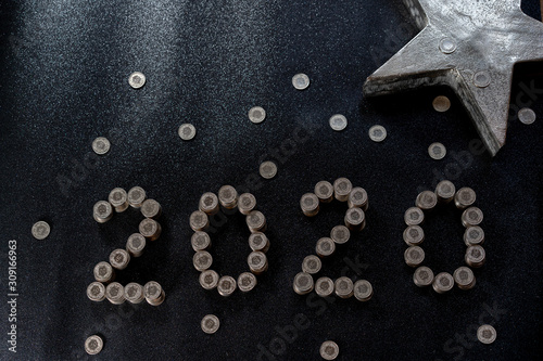 Money coins from Switzerland on a black shiny ground with silver star for concept. Concept for 2020, new years and saving Money, cash and crisis. High angle view.
