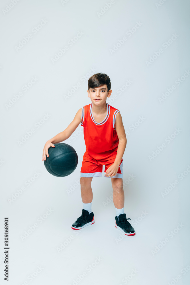 Boy playing basketball on studio