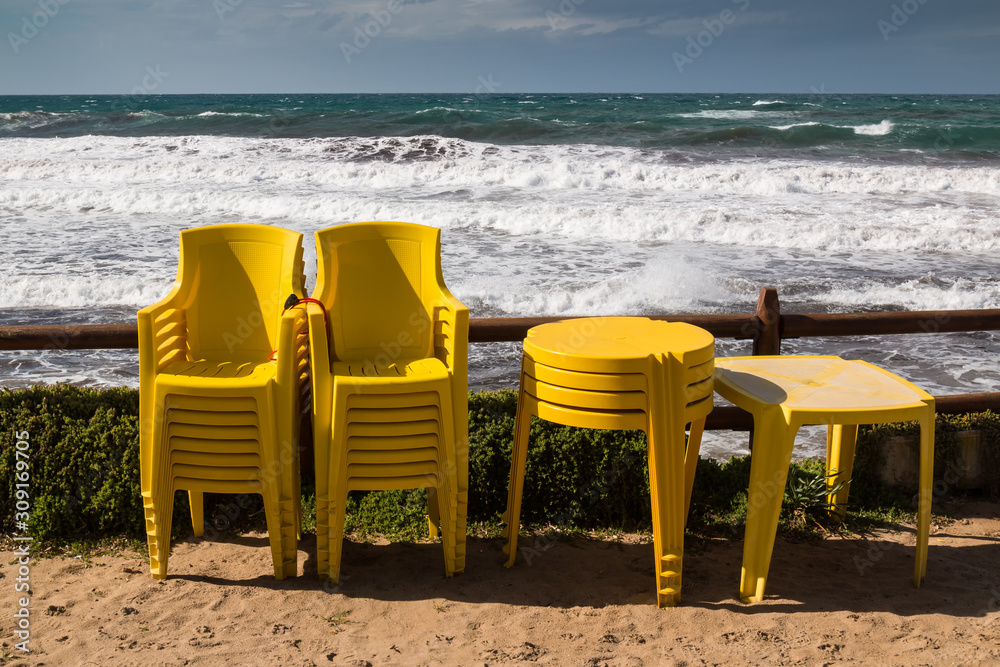 Yellow chairs and tables and a sea Yellow chairs and tables and a sea