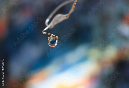 drop of water on a wire on the background of a reproduction of Monet