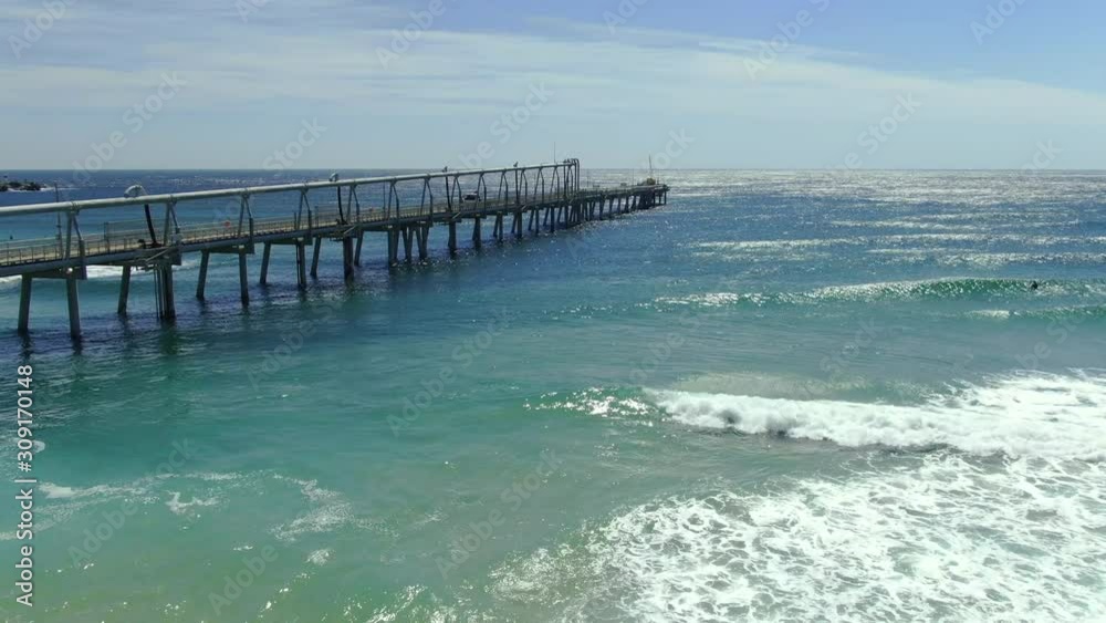 Flying out slowly towards the end of Gold Coasts sand pumping jetty on a clear morning with a peaceful swell rolling in.Queensland Australia Flying out slowly towards the end of Gold Coasts sand pumping jetty on a clear morning with a peaceful swell rolling in.Queensland Australia