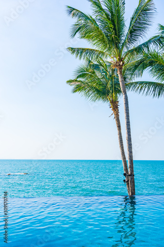 Luxury outdoor swimming pool in hotel resort with coconut palm tree