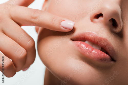 cropped view of woman pointing with finger at lips isolated on white