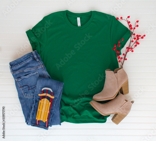 Green shirt top view and styled with Christmas items - white background