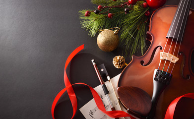 Violin with bow and sheet music on black background elevated