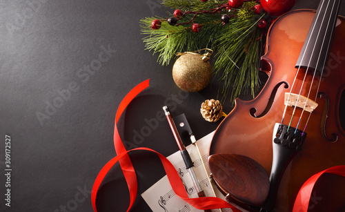 Violin with bow and sheet music on black background elevated