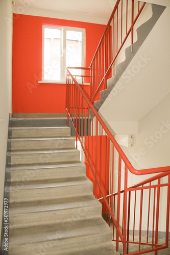 Light from the window on the stairs in a new multi-storey building. Clean entrance, orange color