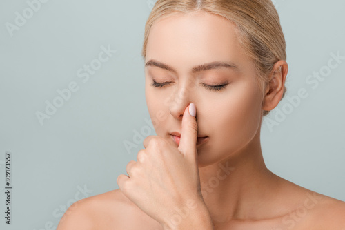 attractive naked woman touching nose isolated on grey