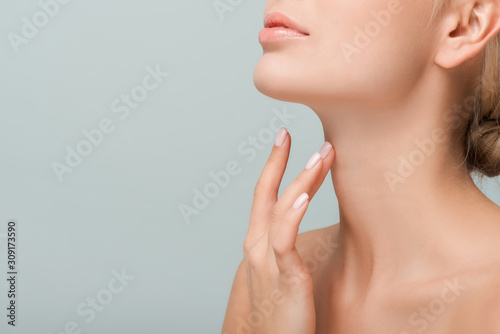 cropped view of woman touching neck isolated on grey photo
