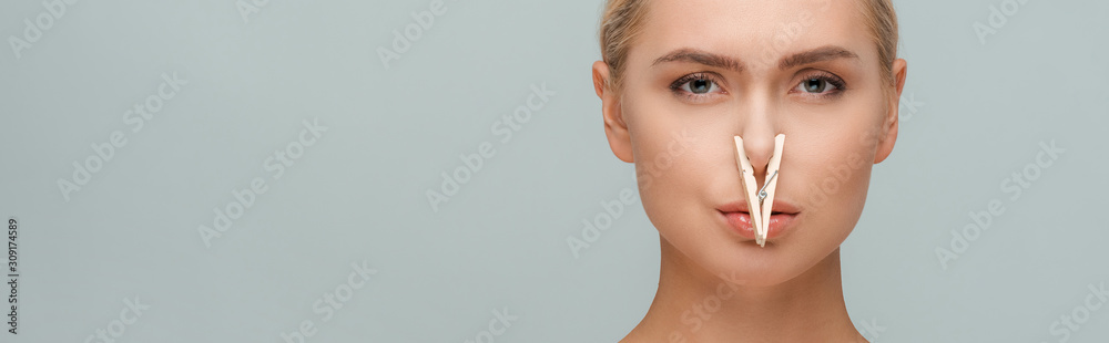 panoramic shot of attractive woman with wooden pin on nose isolated on grey - obrazy, fototapety, plakaty 