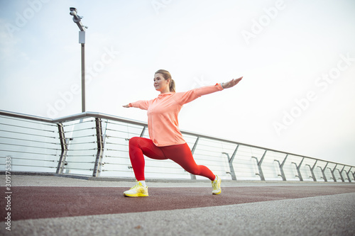 Beautiful sporty girl stretching on the bridge