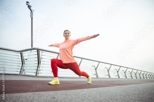 Attractive young woman stretching on the bridge