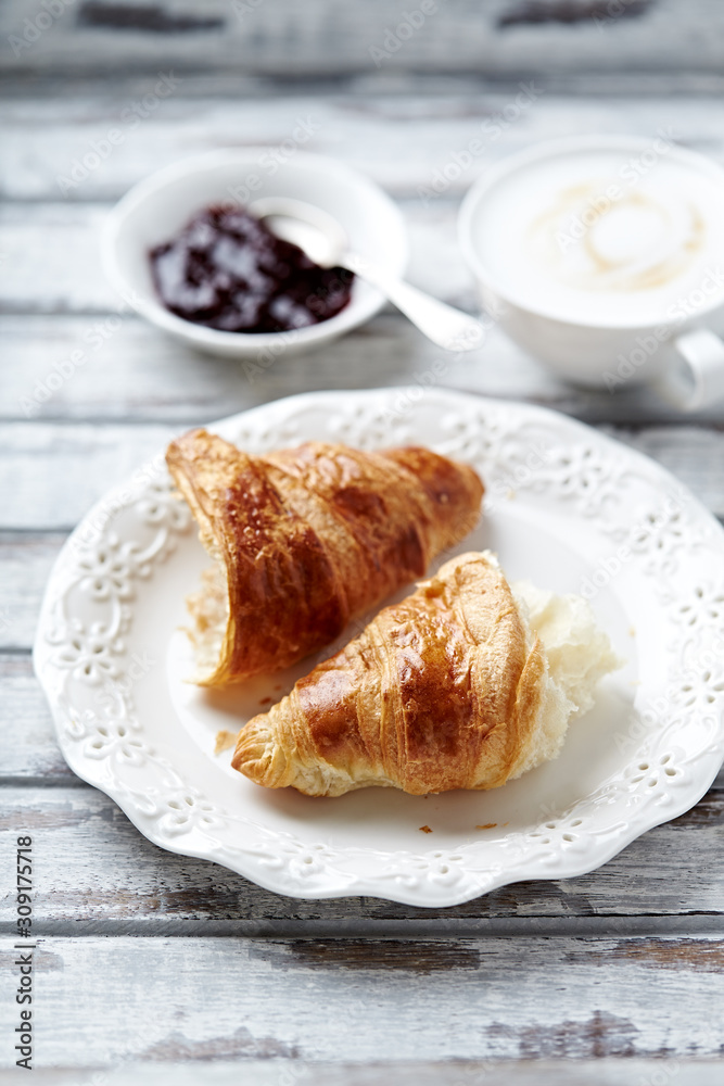 Croissant with coffee and jam. White wooden background. 