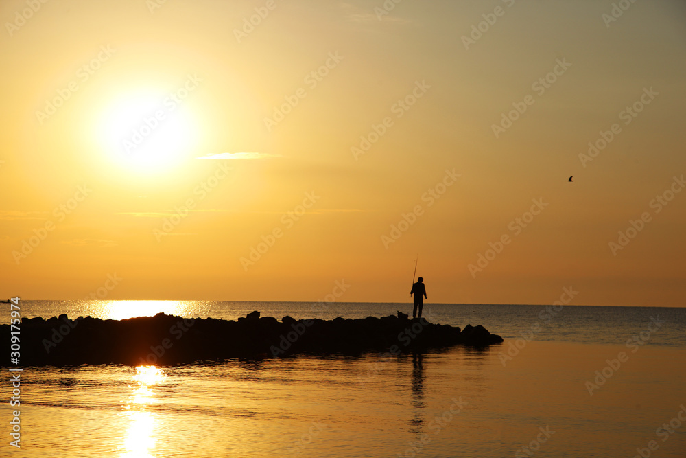 silhouette of fisherman at sunset