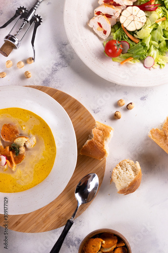 Tableau sur toile Lunch Chicken soup with croutons and chicken breast salad and wine on a light ba