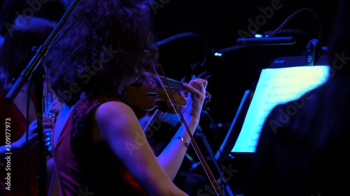 Classical musician violinist with a musical instrument violin playing at the concert