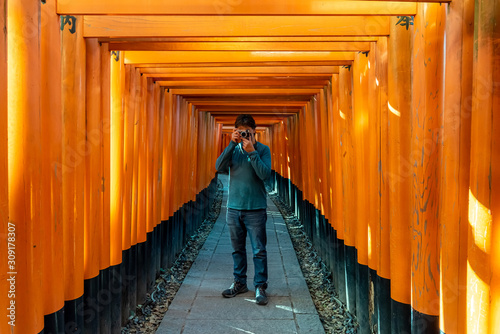 Man taking pictures at Fushimi Inari Shrine. Kyoto, Japan