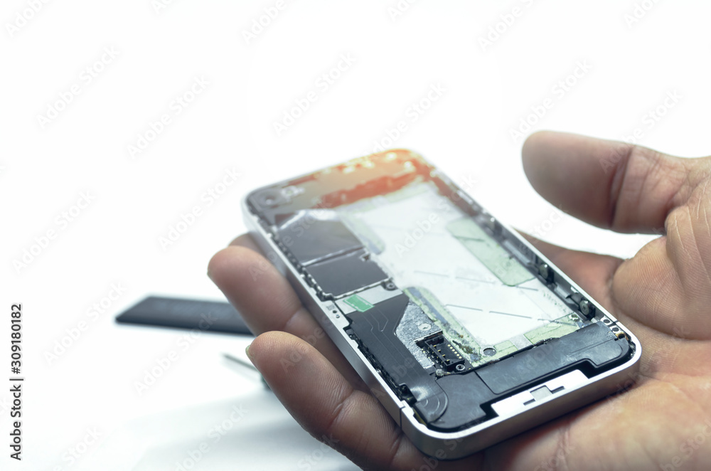 Close-up of Iphone repairs install battery into the motherboard for smartphone By technician on studio white background With mini tools Close-up of Iphone repairs install battery into the motherboard for smartphone By technician on studio white background With mini tools