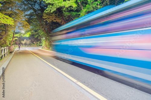Photography A bus going up the forest road at night