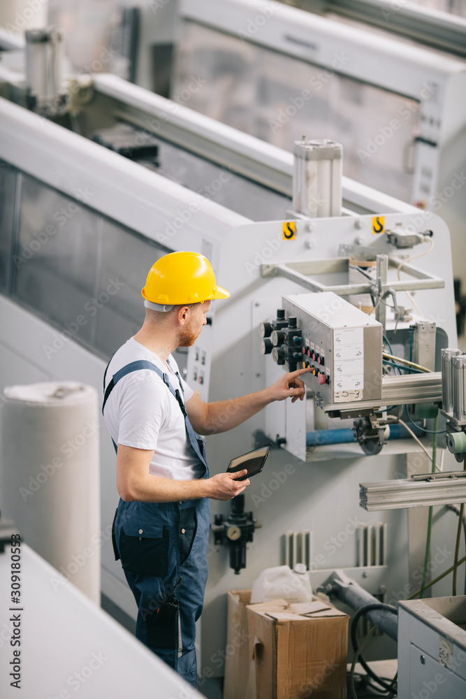 Man with helmet working in factory. Man with helmet working in factory.