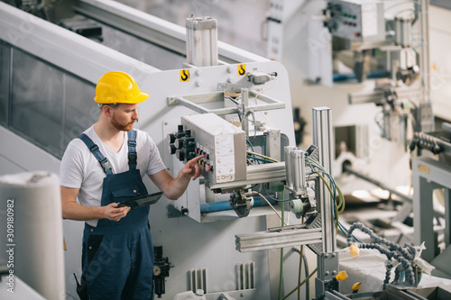 Man with helmet working in factory.