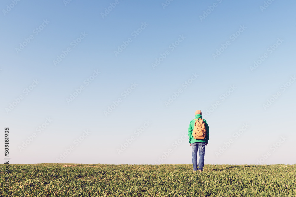 Tourist with backpack alone on summer field. Travel concept Tourist with backpack alone on summer field. Travel concept