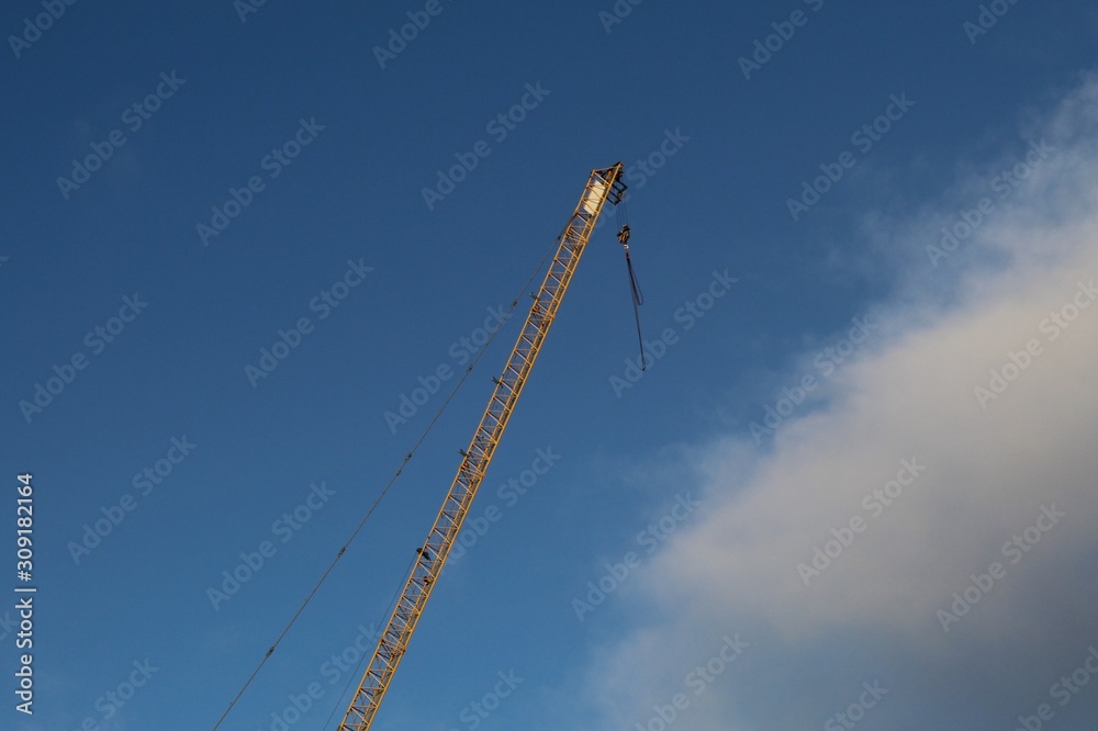 Yellow crane in the wind on blue sky background Yellow crane in the wind on blue sky background