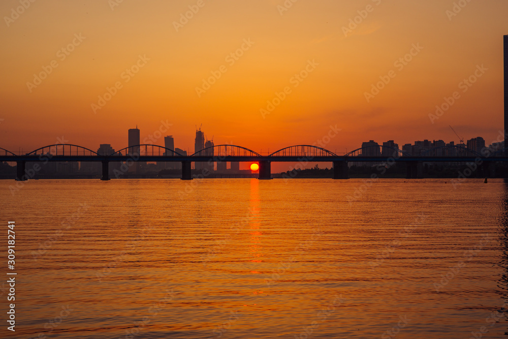Naklejka premium Sunset under the bridge between sky scrappers at Dongjak Bridge, Seoul, Korea.
