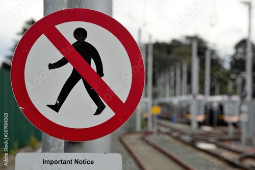 A sign warning pedestrains not to cross train tracks photo