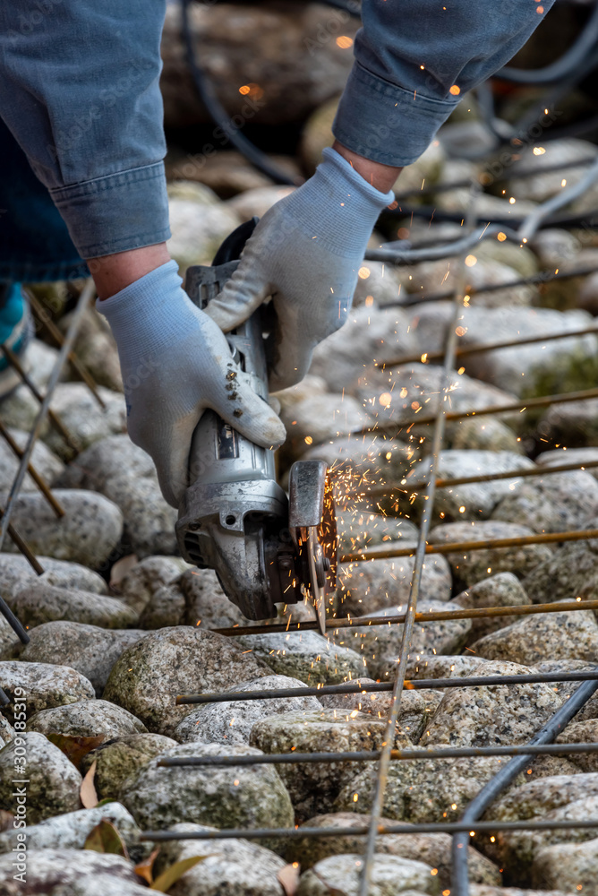 Obraz premium Metal worker cutting steel with a radial saw