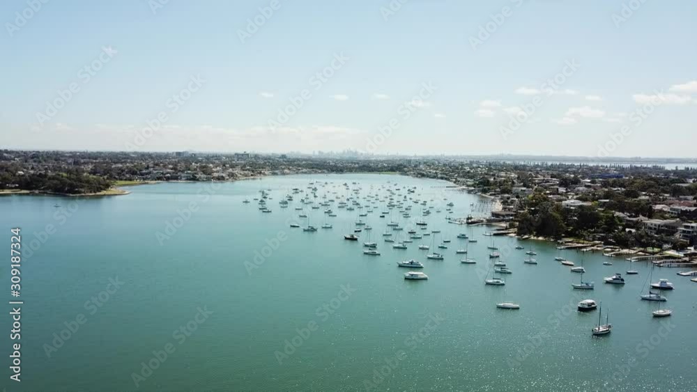Aerial: Drone flying across a beautiful bay towards the city skyline on the horizon, in Sydney NSW Aerial: Drone flying across a beautiful bay towards the city skyline on the horizon, in Sydney NSW