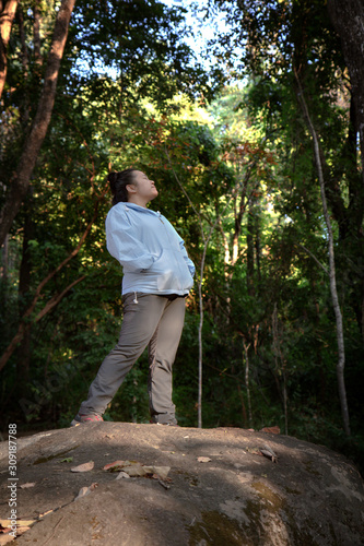 Relaxing in Nature : Asian woman standing on the forest. Chubby woman enjoying relaxing in the wild
