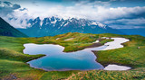 Majestic evening view of Koruldi  lake in the Caucasus Mountains. Gloomy summer scene of popular touristic destination in Upper Svaneti, Georgia, Europe. Beauty of nature concept background..
