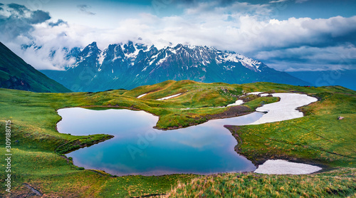 Majestic evening view of Koruldi lake in the Caucasus Mountains. Gloomy summer scene of popular touristic destination in Upper Svaneti, Georgia, Europe. Beauty of nature concept background..