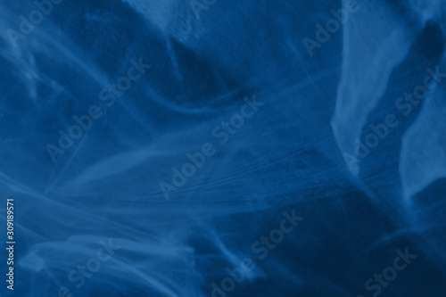Trendy blue colored low contrast abstract background with light and shadows caustic effect. Light passes through a glass. Water background. 2020 year color trend