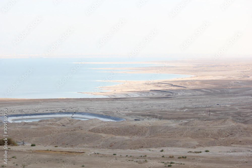 Long shot view of the Dead Sea of Israel with salt land. Dry salt land echo dry salt at the Dead sea.